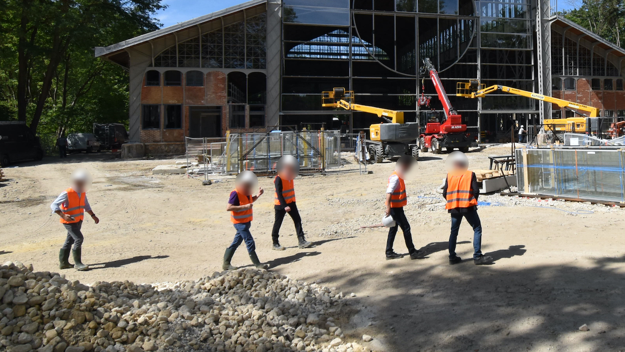 Un groupe d'ouvriers se promène sur le chantier du Hangar Y