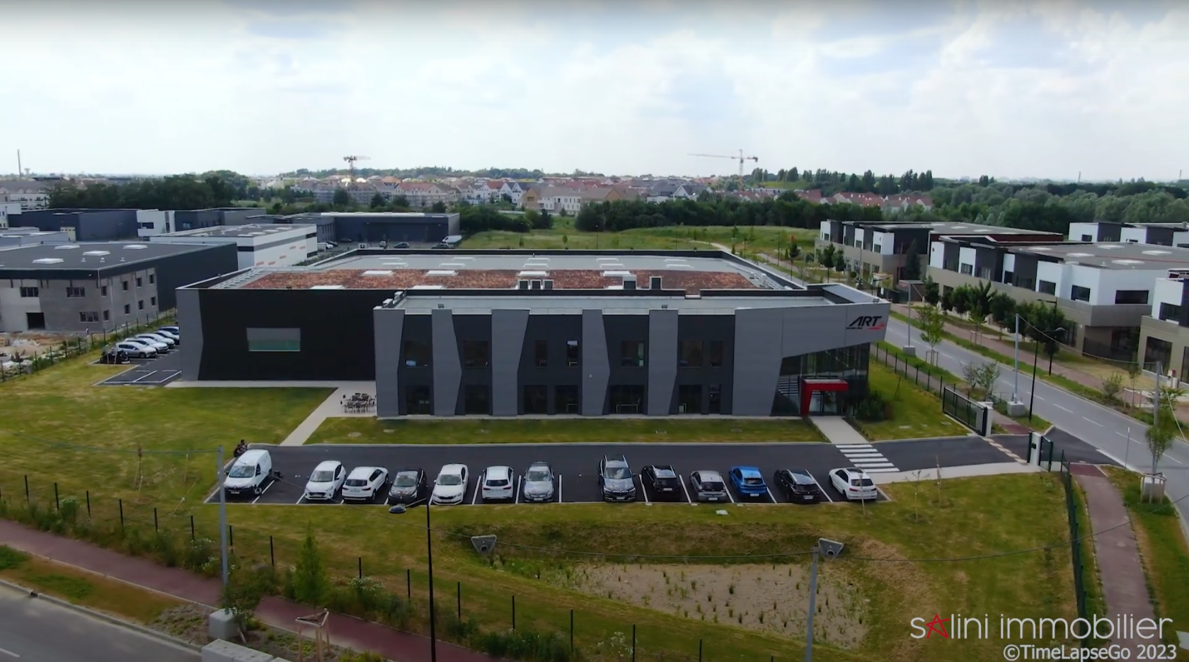 Bureaux de ART GP avec des voitures garées devant, vu d'en haut.