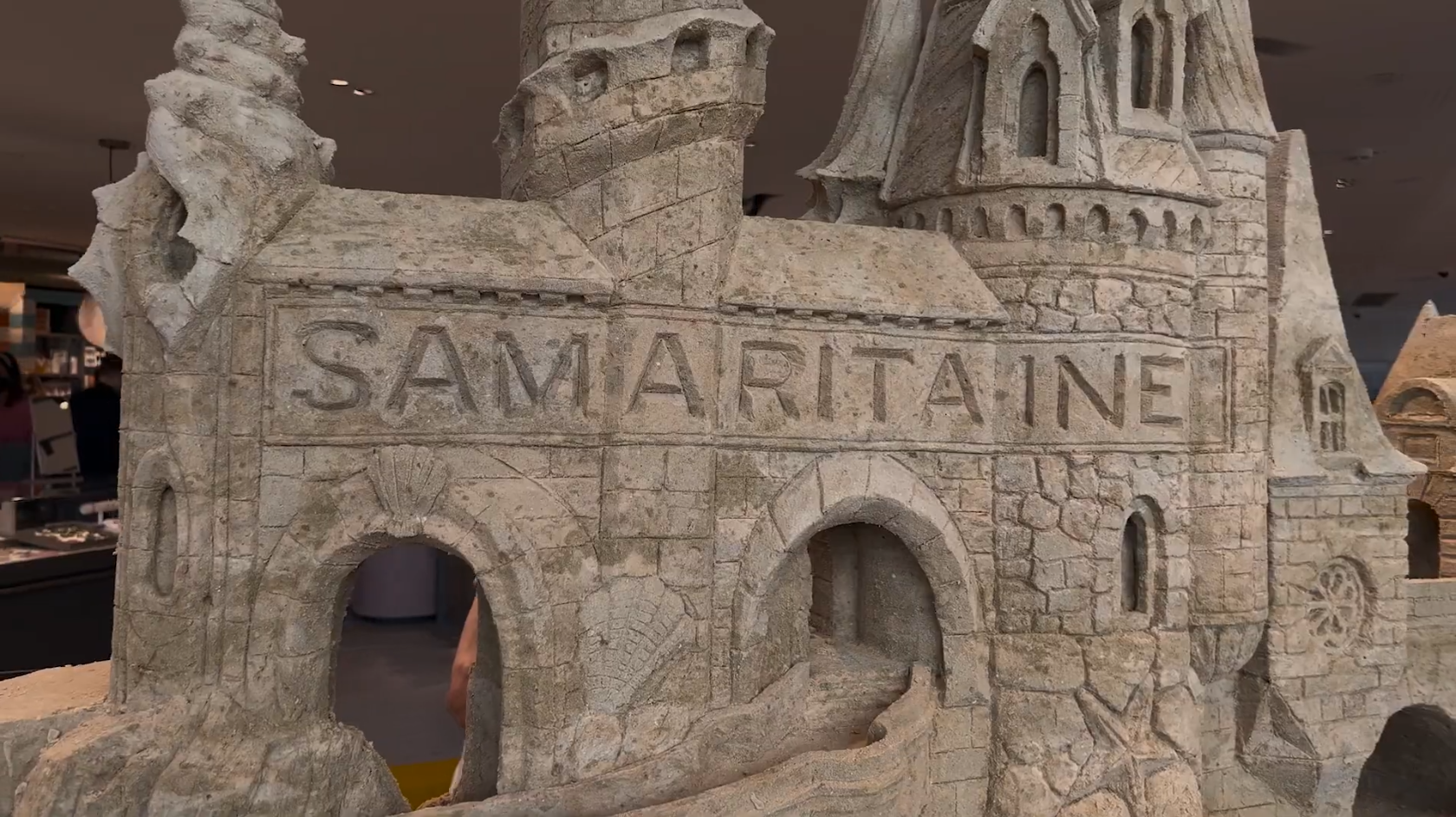 Château de sable avec le mot "Samaritaine" écrit dessus.